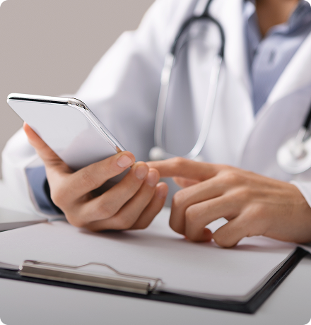 Doctor using smartphone for patient communication in healthcare.